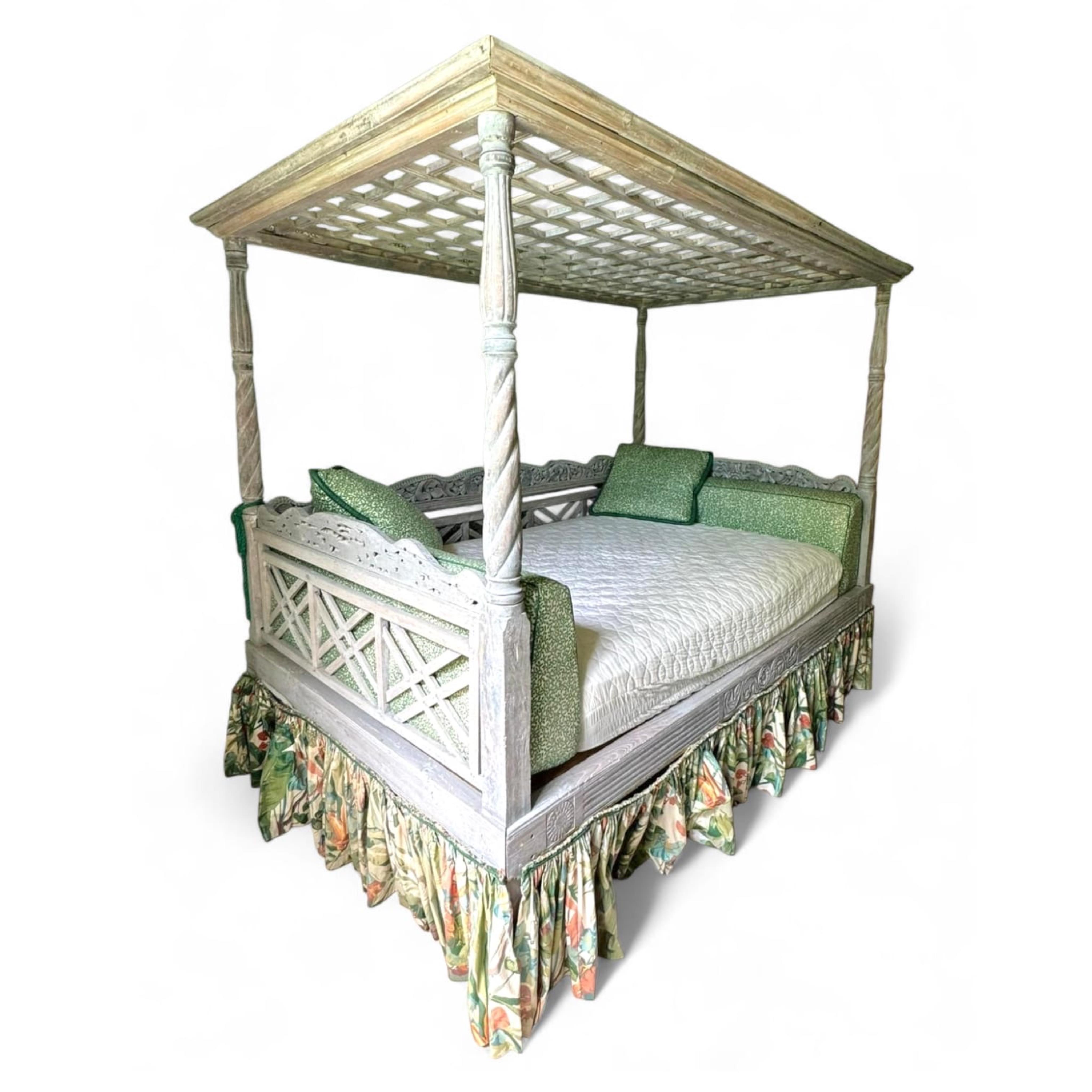 An Indian grey painted carved teak four poster double bedstead, with a pierced canopy over